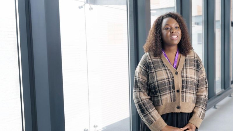 Smiling woman in a modern office environment.